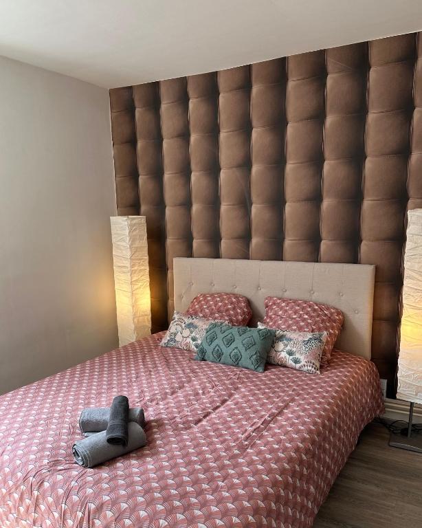 - une chambre avec un grand lit et une grande tête de lit rembourrée dans l'établissement Appartement hyper-centre Stella, à Dunkerque