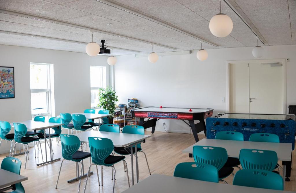 una sala con tavoli, sedie e tavolo da biliardo di First Camp Holbæk Fjord a Holbæk