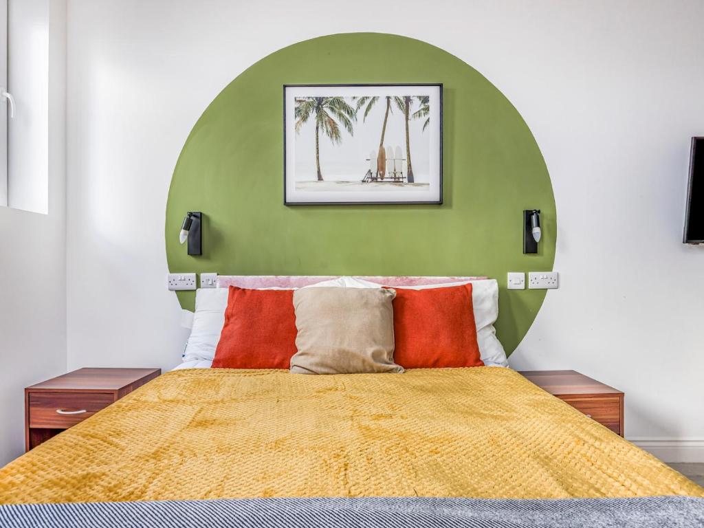 a bedroom with a large bed with a yellow blanket at Stylish Studio Apartment in Portsmouth