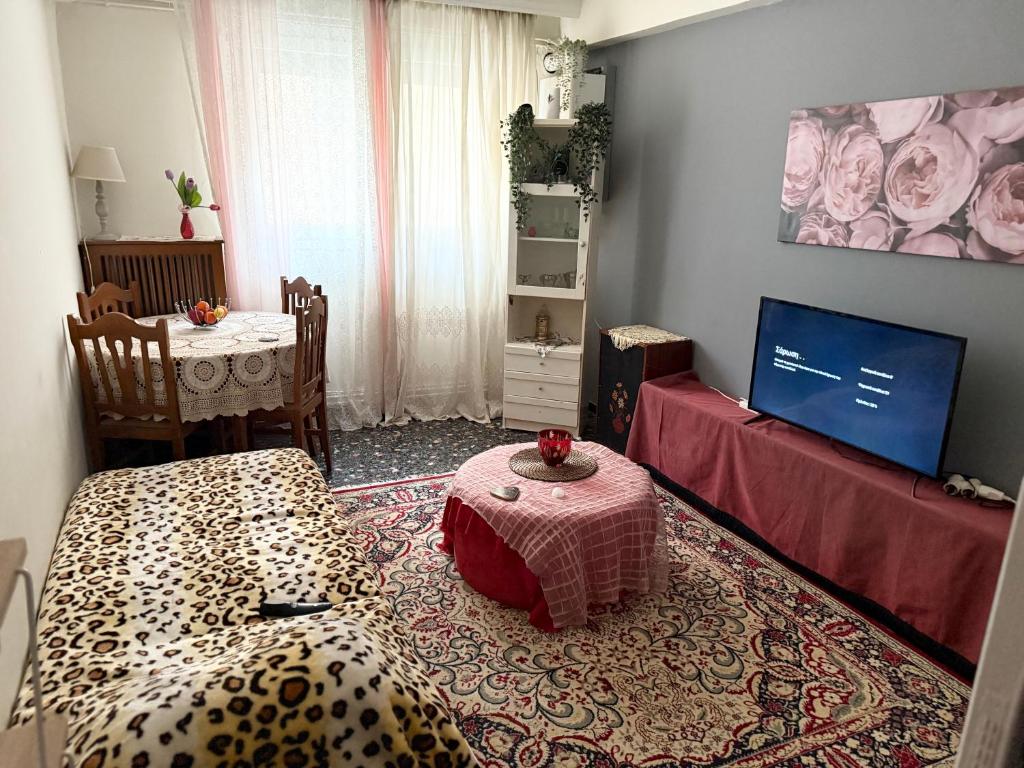 un salon avec une table et une télévision dans l'établissement Mona Lisà, à Larissa