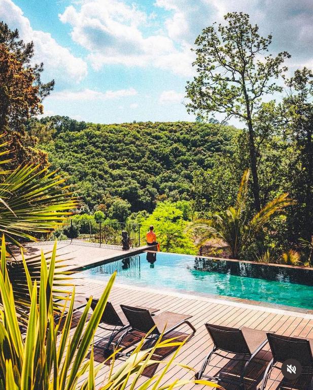 une personne debout à côté d'une piscine avec des chaises dans l'établissement 