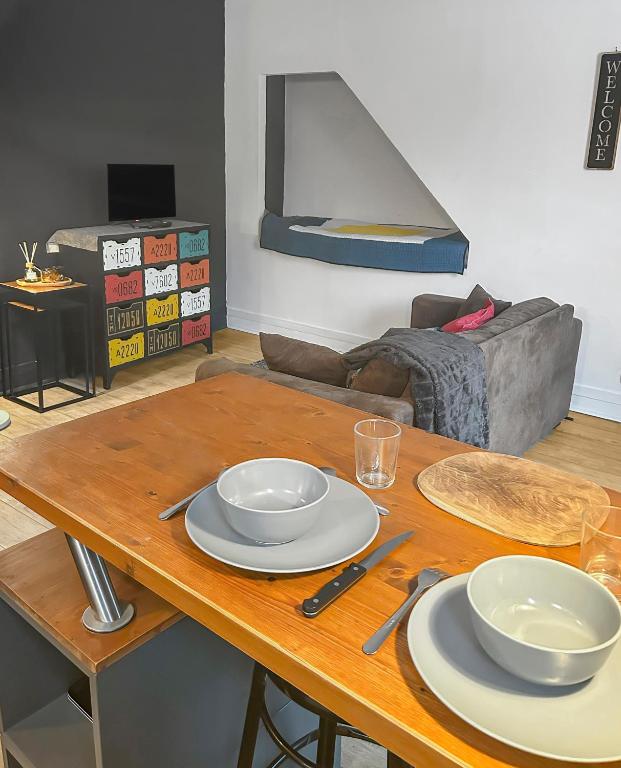 une table en bois avec deux plaques au-dessus dans l'établissement Studio Le Montebello - Vintage, WiFi et Netflix, à Fontainebleau