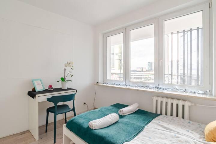 a bedroom with a bed and a desk and windows at Central Warsaw Gem in Warsaw