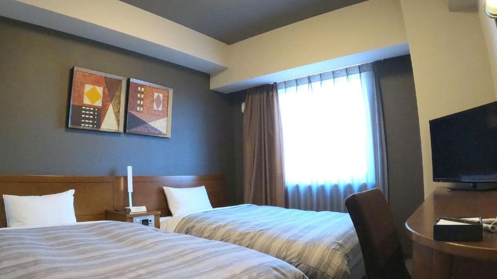 Postel nebo postele na pokoji v ubytování Hotel Route-Inn Gotenba Eki-Minami