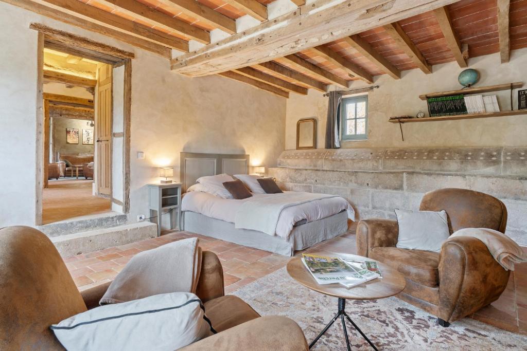 a bedroom with a bed and chairs in a room at Gîte de charme en rez de jardin in Berdʼhuis