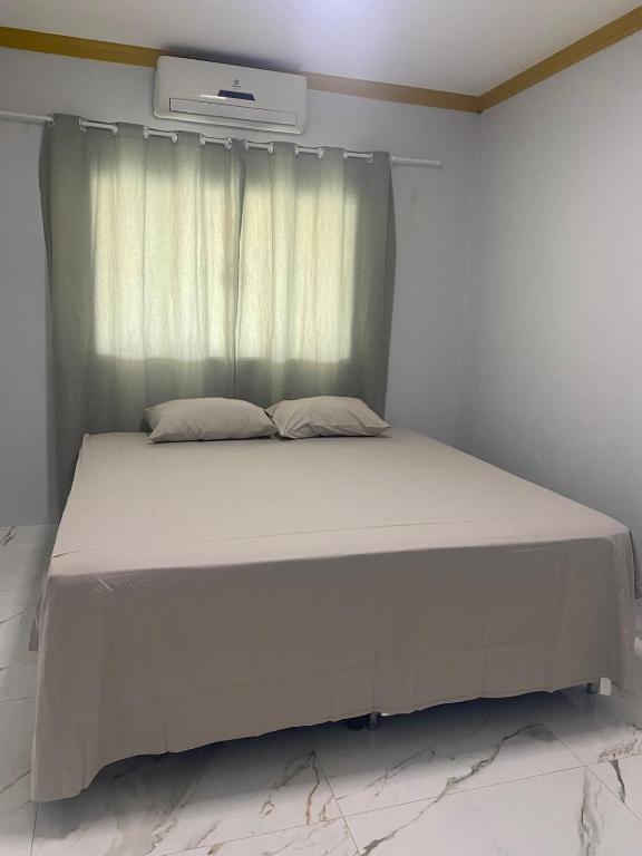 een bed in een kamer met een raam bij Hospedagem da Lili in Palmas