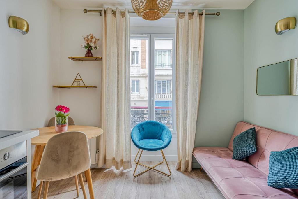 - un salon avec un canapé rose et une chaise bleue dans l'établissement Apartment in Paris 17th District, à Paris