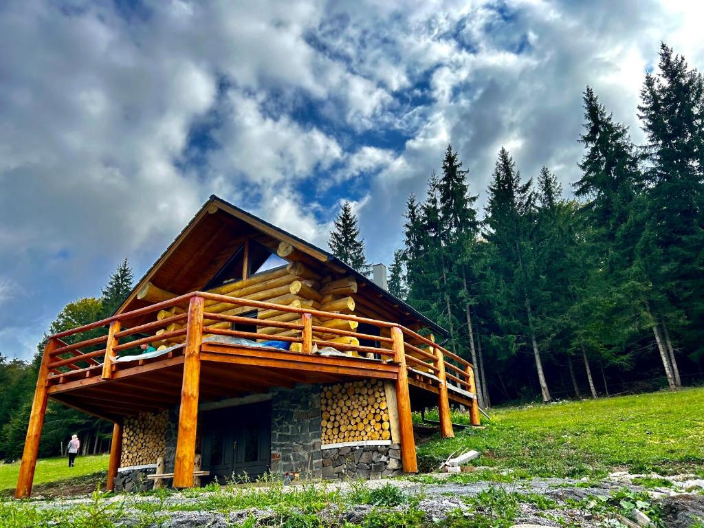 a log cabin with a deck on the side of it at Nyugalom Rönkhàz in Mureş-Sat