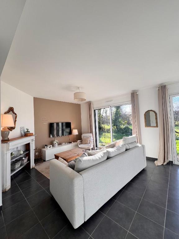 un salon avec un canapé blanc et une télévision dans l'établissement Maison moderne sur le port, à Loperhet