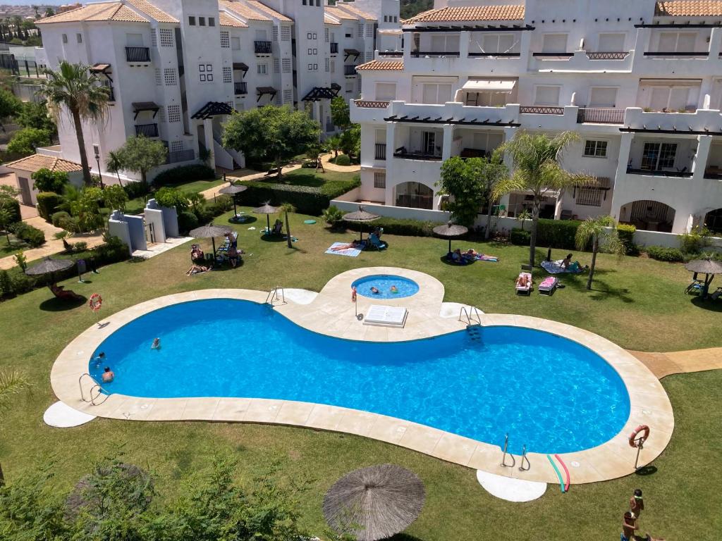 einen Blick über einen großen Pool vor einem Gebäude in der Unterkunft Lägenhet högst upp, med pool och utsikt över havet in San Luis de Sabinillas