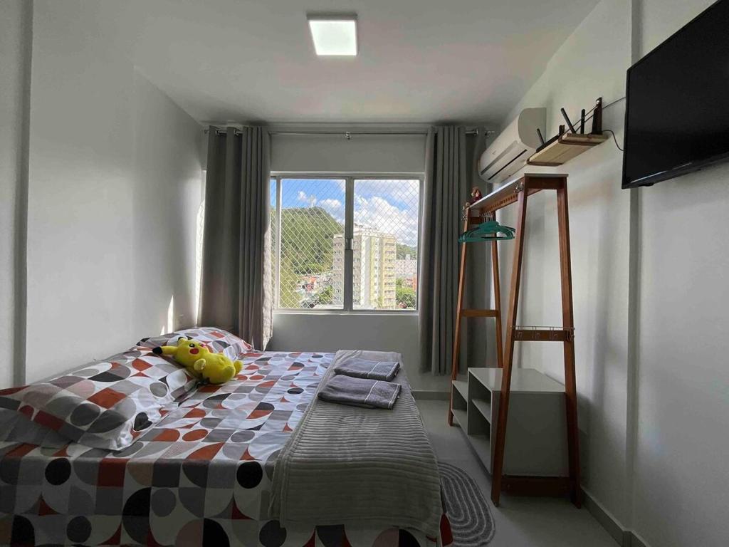 a bedroom with a bed and a ladder and a window at Studio Balneário Camboriú SC Com Vista Para o Cristo Luz Perto da Praia in Balneário Camboriú