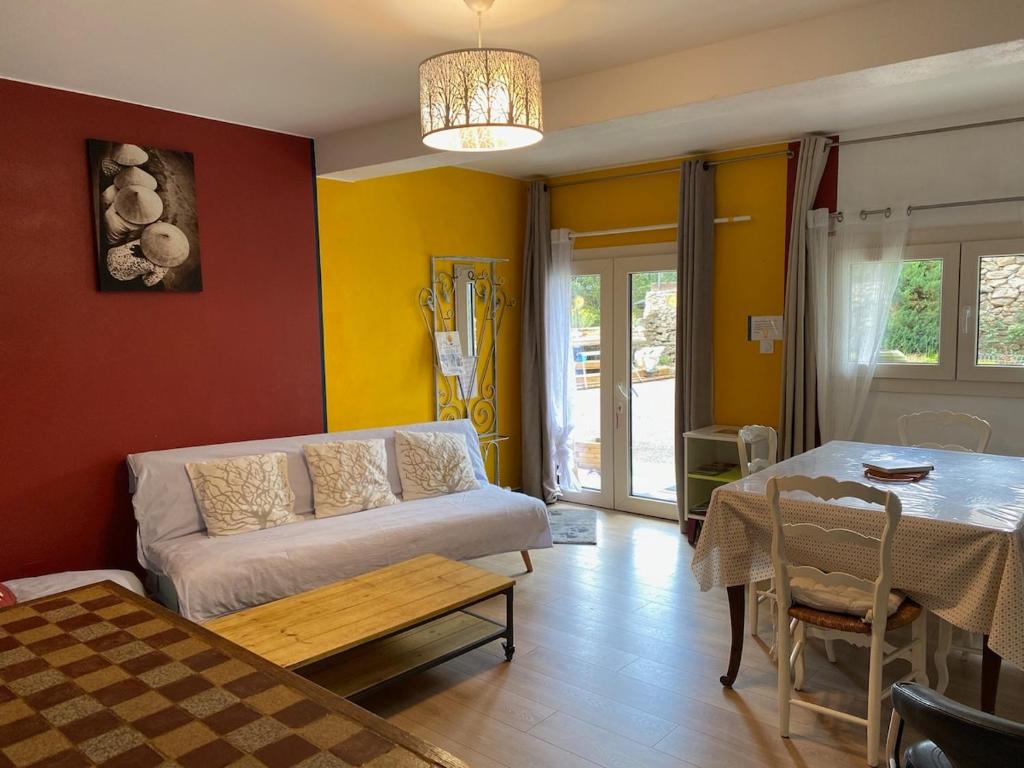 un salon avec un canapé et une table dans l'établissement Catalunya Les 3 gîtes jardin vue montagne calme T2, à Dorres