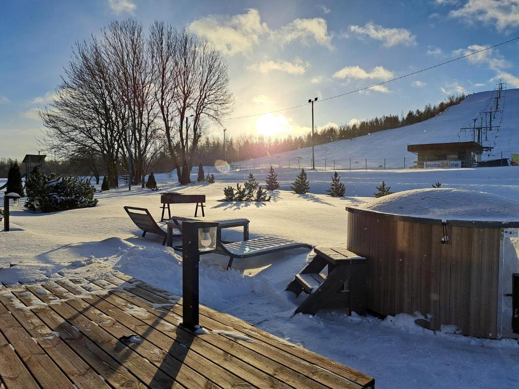 un tavolo da picnic e una panchina nella neve di Tuhamäe Hostel a Kiviõli