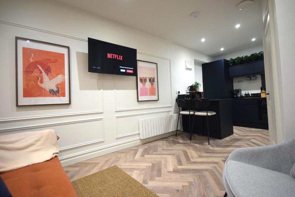 a living room with a tv on the wall at CITYeSCAPE - 1-Bed Apt 1 Bath Sofa bed NQ in Manchester