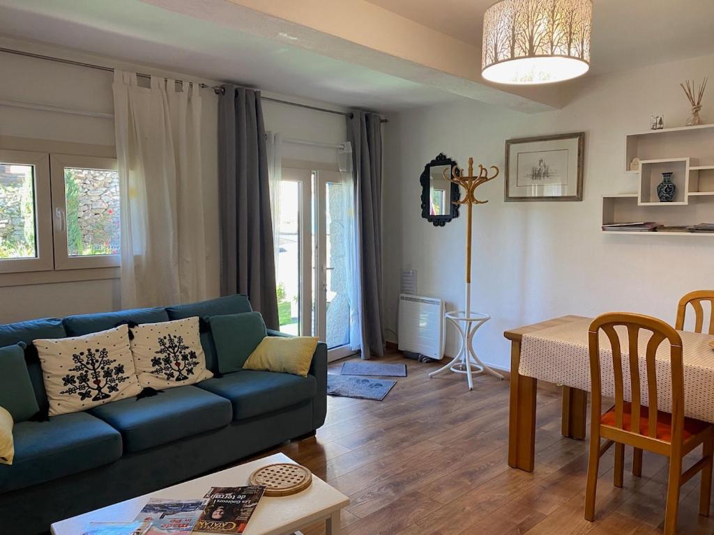 un salon avec un canapé bleu et une table dans l'établissement Maillol Les 3 gîtes joli jardin calme ancien T1, à Dorres
