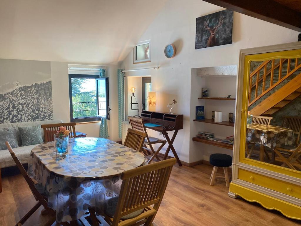 une salle à manger avec une table et des chaises et un escalier dans l'établissement Okaido Les 3 gîtes vue montagne jardin ancien T3, à Dorres