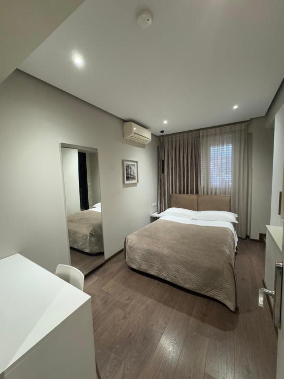 a bedroom with a large bed and a mirror at Hotel Oresti Center in Tirana