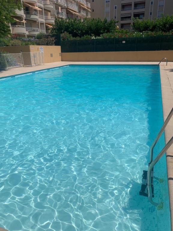 une grande piscine bleue devant un immeuble dans l'établissement T3 avec piscine et proche de la mer 5mns à pied, à Saint-Raphaël