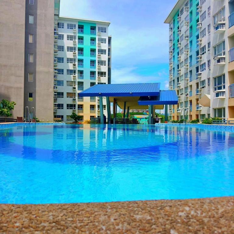 a large swimming pool with blue water in front of buildings at 3BR Davao Condo 7thfloor near Airport in Pagamikan