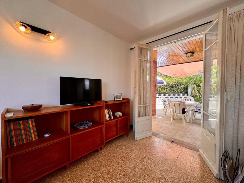 d'un salon avec une télévision et une porte coulissante en verre. dans l'établissement Maison Garriga, à Béziers