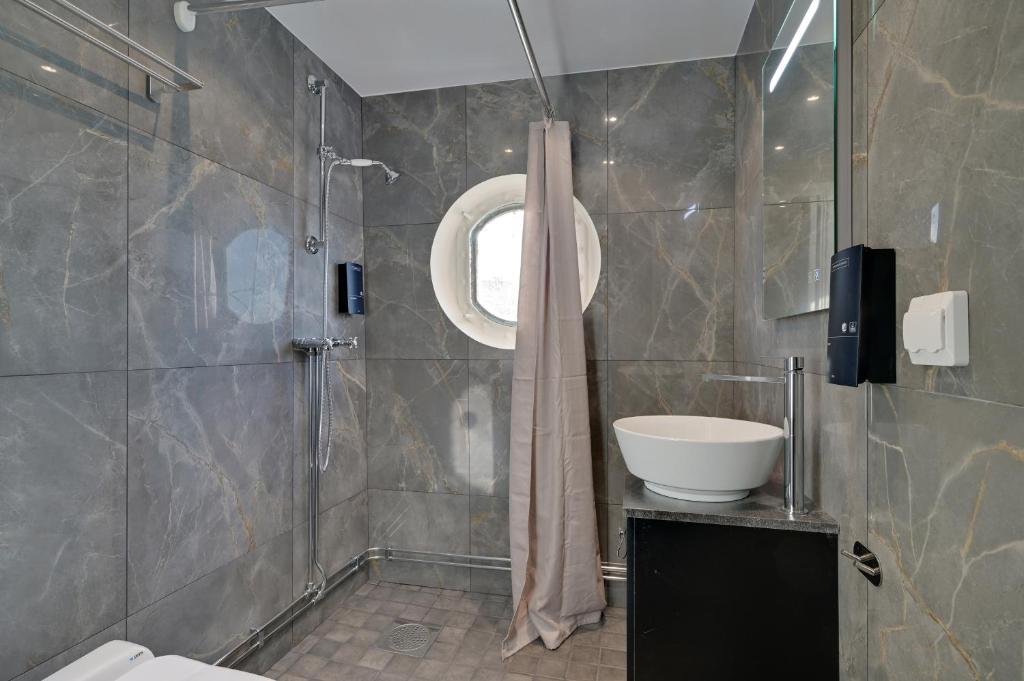 a bathroom with a shower and a sink at Mälardrottningen Yacht Hotel in Stockholm