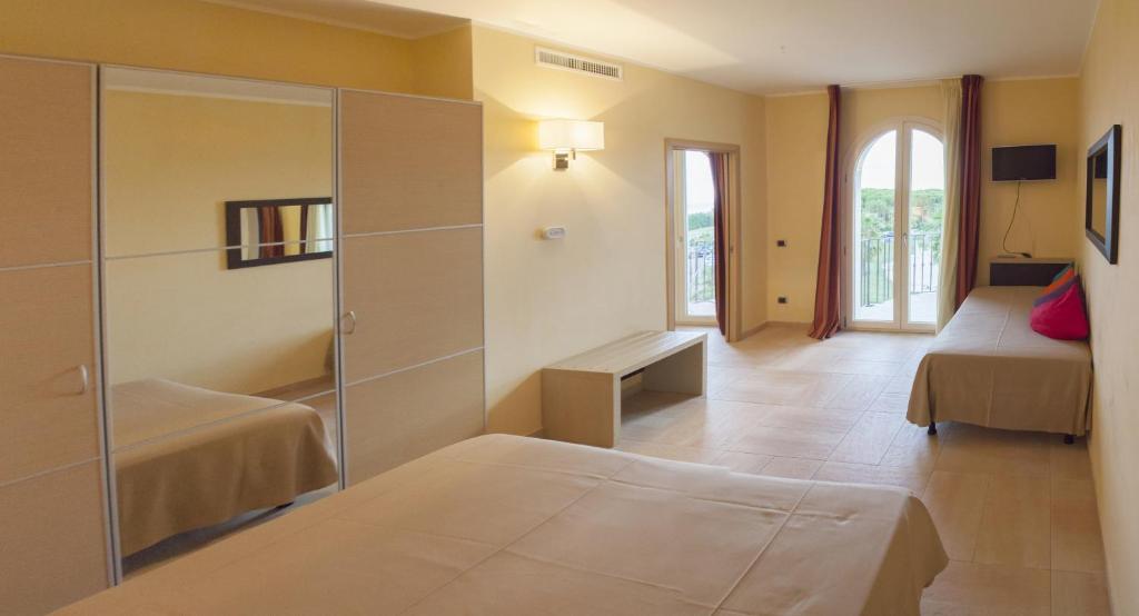 Pokój z 2 łóżkami i przesuwnymi szklanymi drzwiami w obiekcie BV Airone Resort w mieście Marina di Sibari