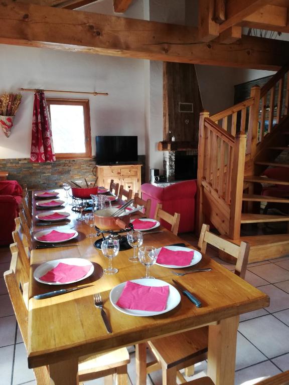 une table en bois avec des assiettes et des serviettes dans l'établissement Appartement 11 personnes, à Saint-Martin-de-Belleville