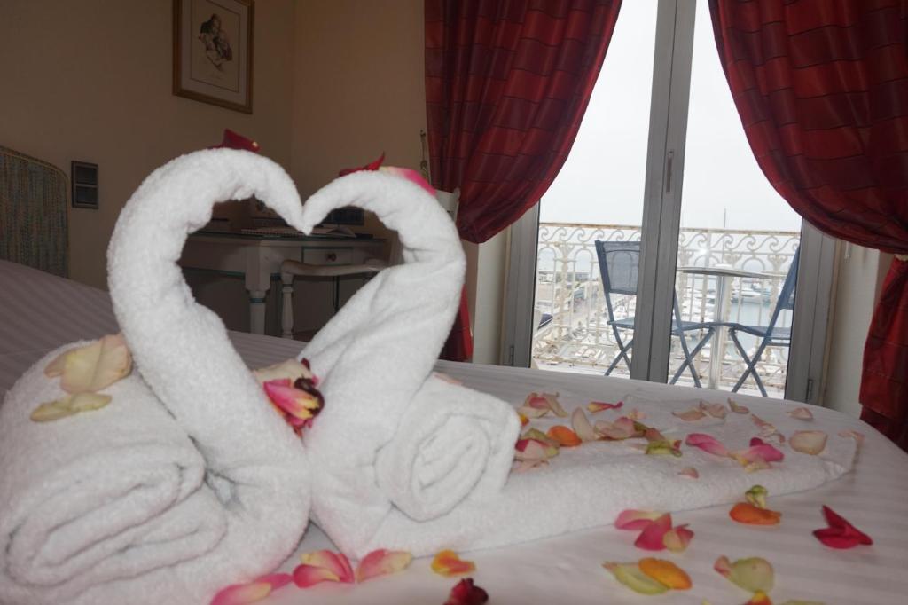 two swans made out of towels on a bed at Hotel Splendid in Cannes