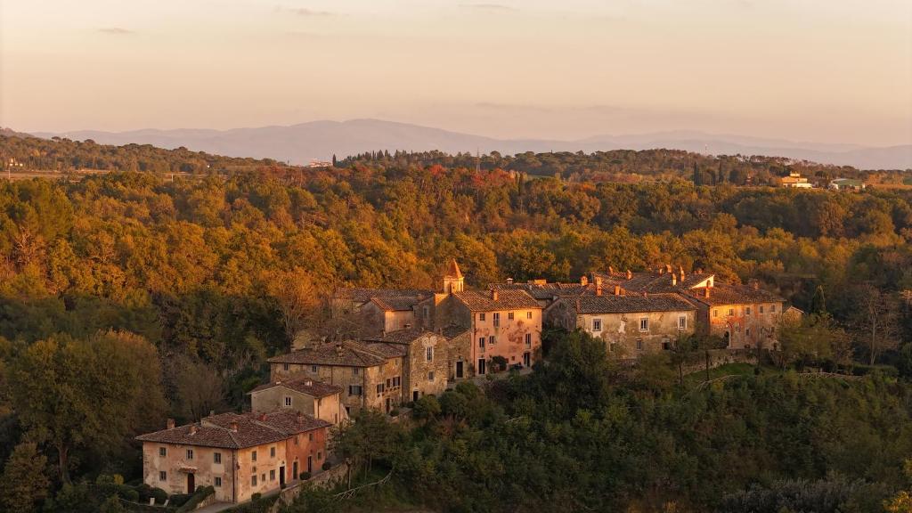grupa budynków na wzgórzu z drzewami w obiekcie Il Borro Relais & Châteaux w mieście San Giustino Valdarno