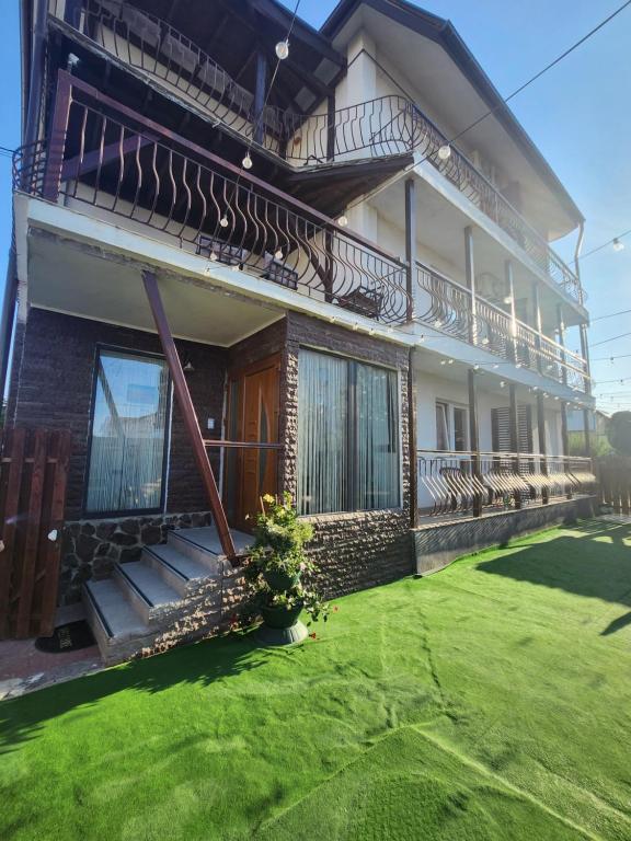 a house with a green lawn in front of it at Casa Daria in Costinesti
