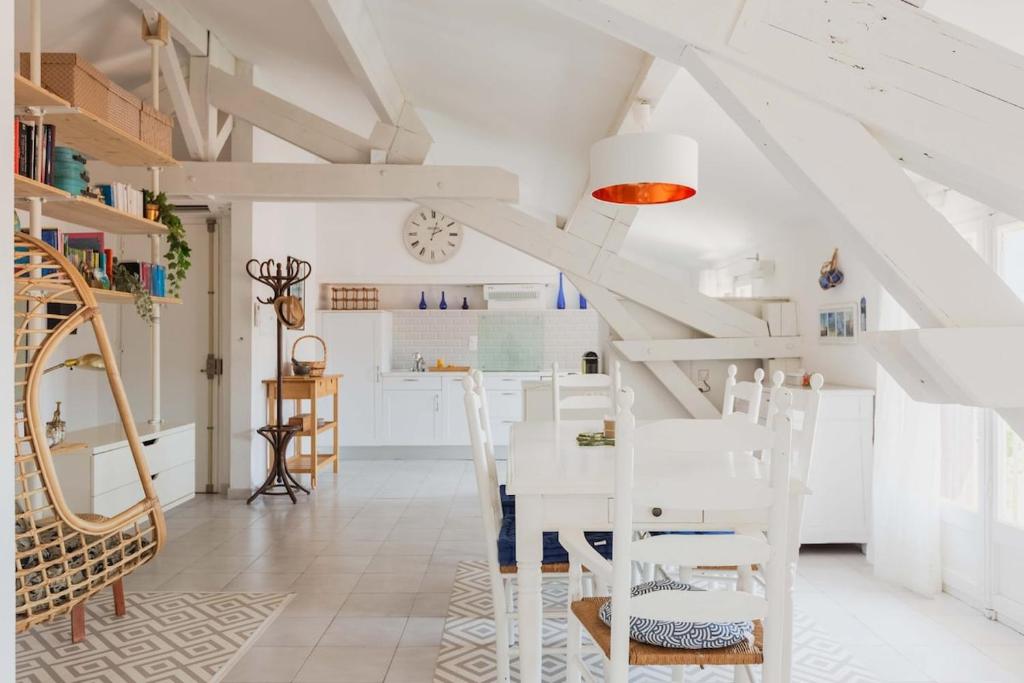 une salle à manger blanche avec une table et des chaises blanches dans l'établissement Regina's Banyuls - Asmaraloka, à Banyuls-sur-Mer