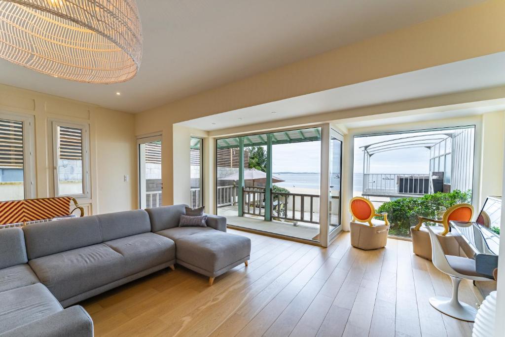 un salon avec un canapé, des chaises et des fenêtres dans l'établissement Somptueuse demeure Arcachonnaise de caractère avec accès direct à la plage, à Arcachon