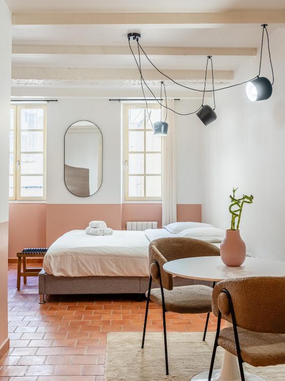 une chambre avec un lit, une table et un miroir dans l'établissement Plein coeur historique vieille ville, à Marseille