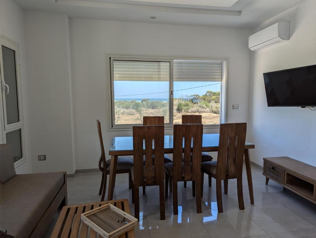 a dining room with a table and chairs and a window at Kelibia Beach appartments in Kelibia
