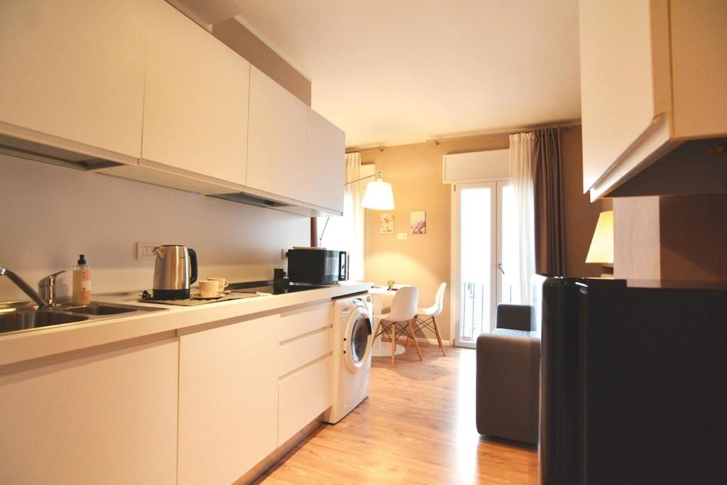 a kitchen with white cabinets and a washer and dryer at Sant'Andrea - soggiorna a due passi dalla storia in Padova