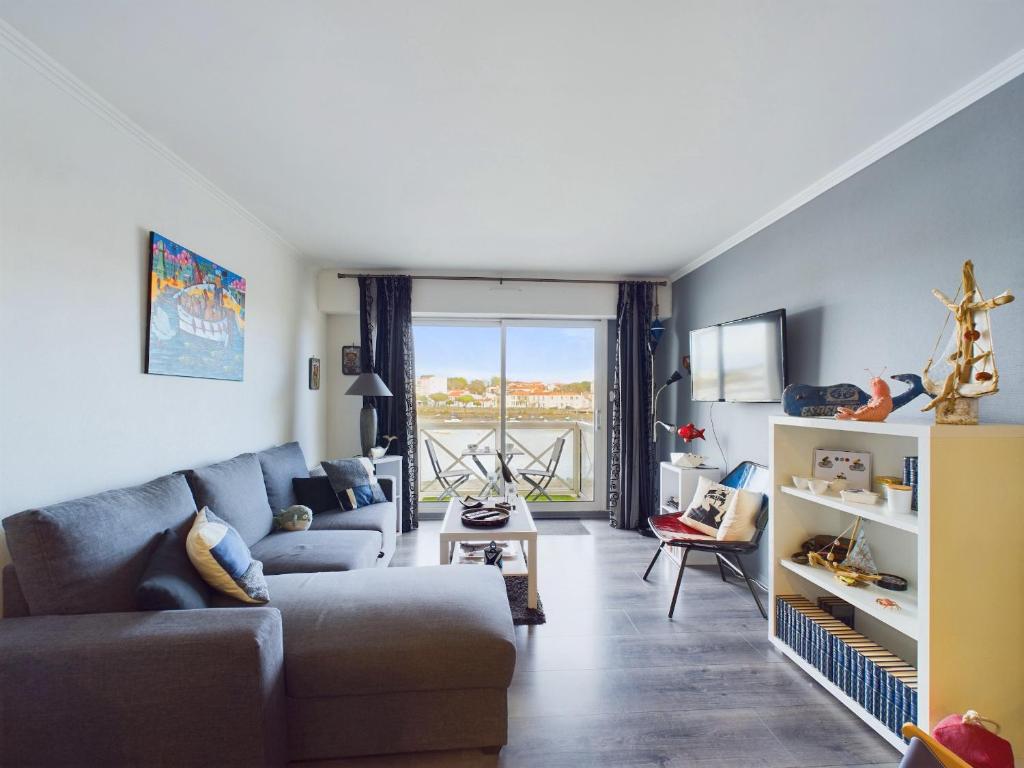 un salon avec un canapé et une table dans l'établissement Appartement cosy pour 4, vue sur la Vie, à Saint-Gilles-Croix-de-Vie