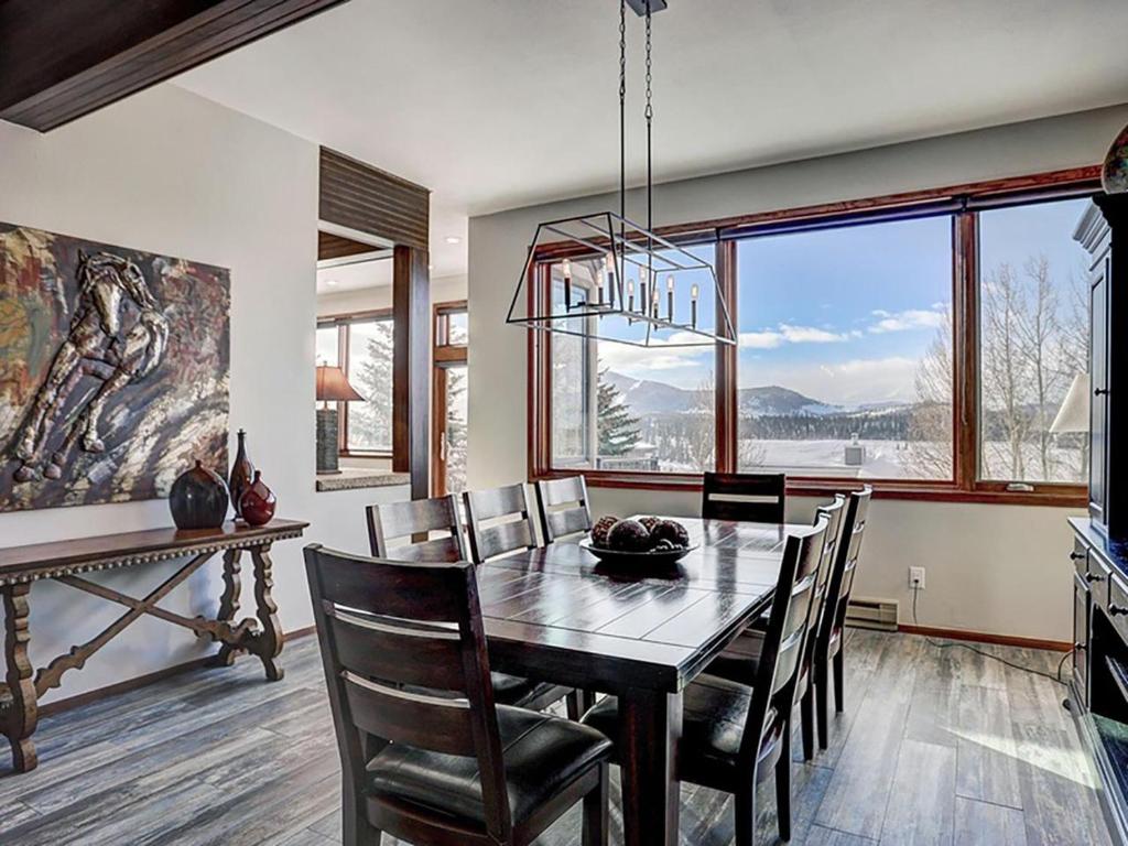 a dining room with a table and chairs and a large window at Luxury By The Lake in Dillon