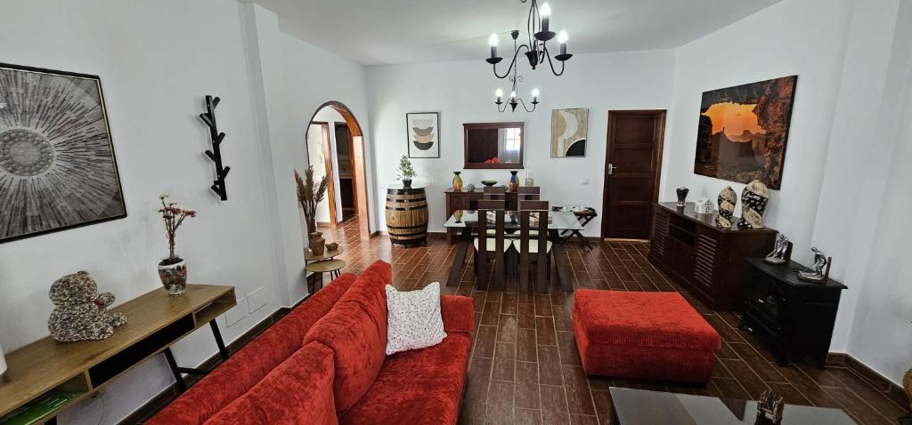 a living room with a red couch and a table at Casa V del Pino in Teror