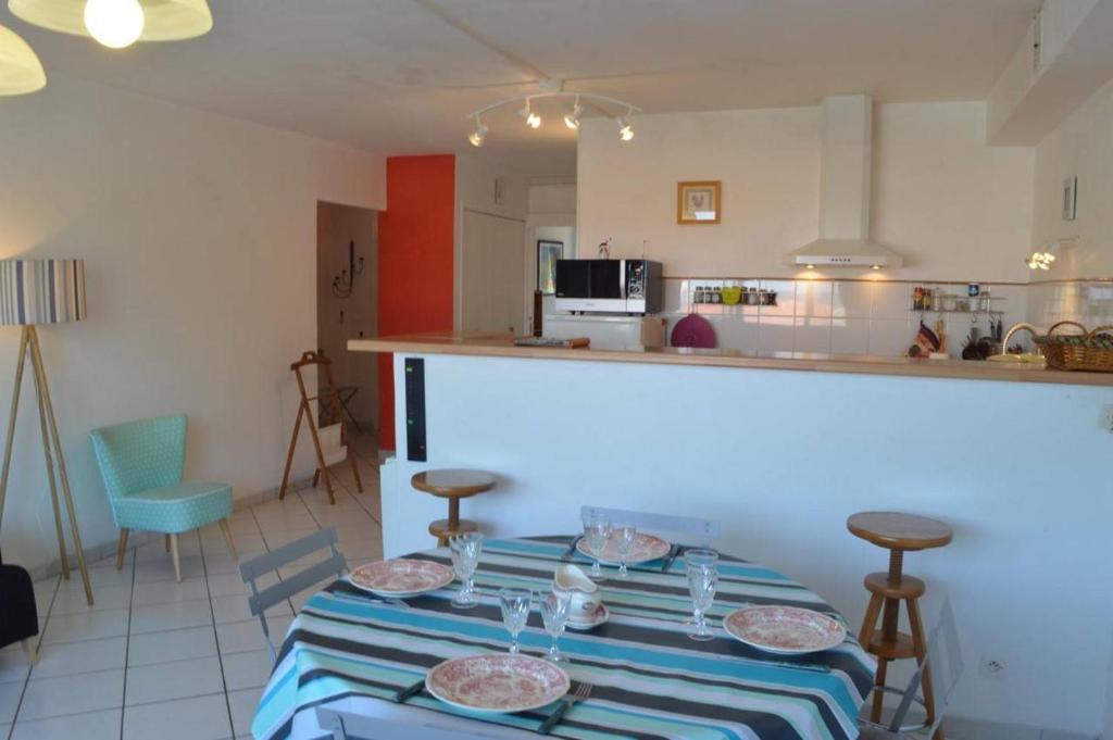 une cuisine avec une table avec des assiettes dessus dans l'établissement Appart 3 pièces 4 couchages BANYULS SUR MER BN100-C601, à Banyuls-sur-Mer