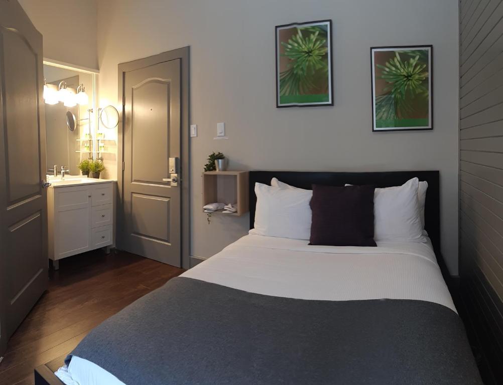 a bedroom with a large bed and a bathroom at Oberge Inn Val-David in Val-David