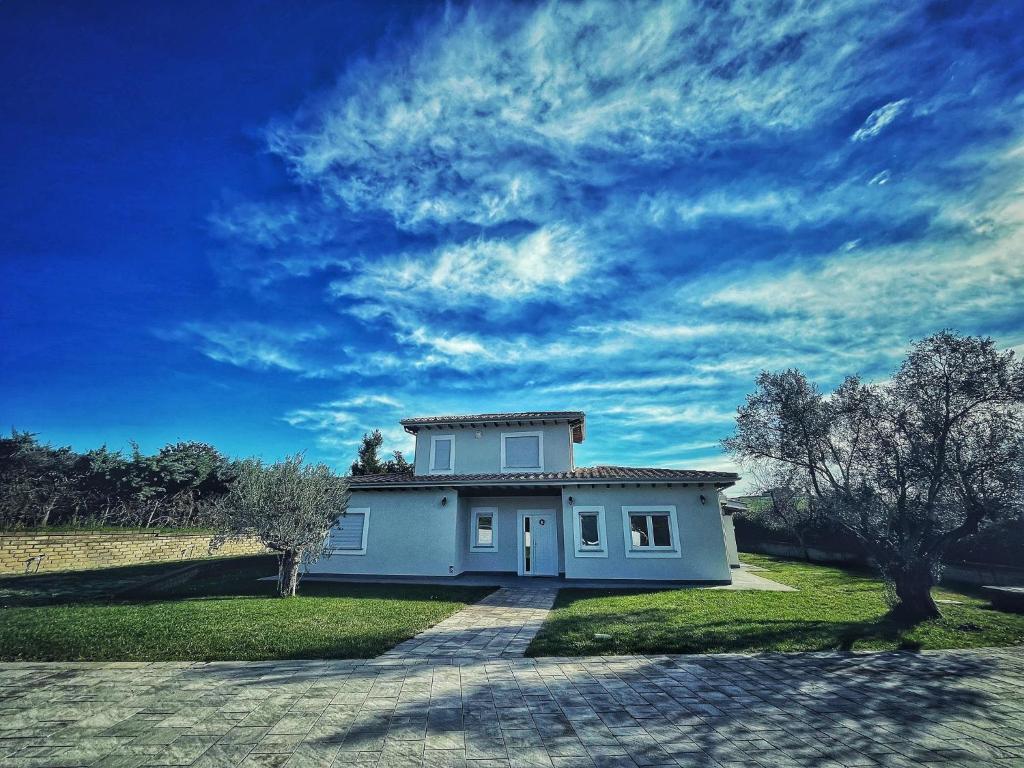 a small white house with a blue sky at Guest House Montestallone in Formello