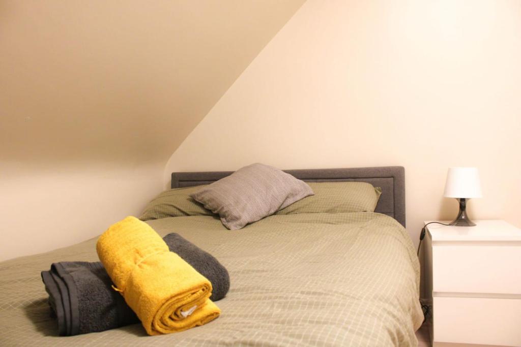 a bedroom with a bed with a yellow blanket on it at 2 bed apartment clan house apartments in Galway
