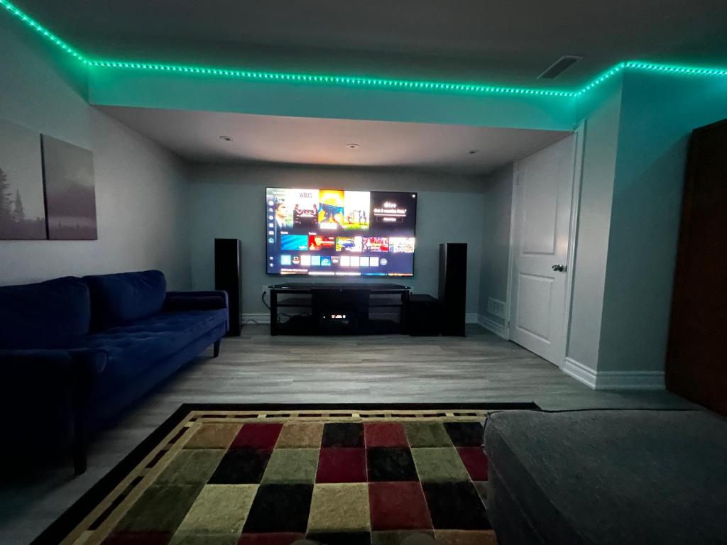 un soggiorno con divano e TV a schermo piatto di Ravine Retreat - 3RM Suite, 2BD, 1 WR, Pool, Sauna a Whitby