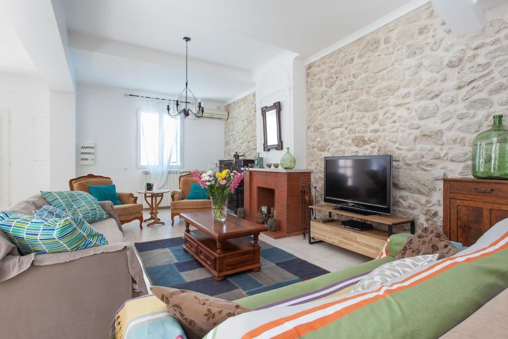 un salon avec un canapé et une télévision dans l'établissement 19th century winemaker's home, à Nissan-lez-Enserune