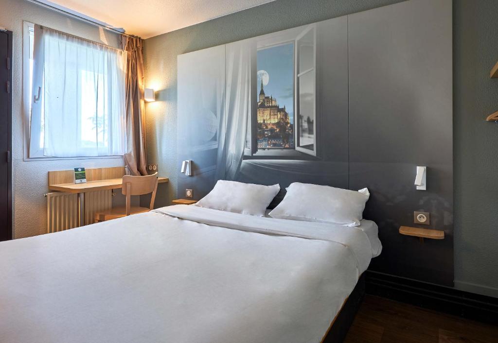Postel nebo postele na pokoji v ubytování B&B HOTEL AVRANCHES Baie du Mont St-Michel