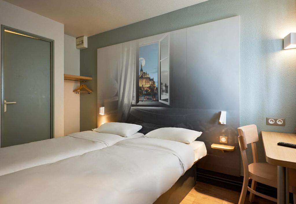 Postel nebo postele na pokoji v ubytování B&B HOTEL AVRANCHES Baie du Mont St-Michel