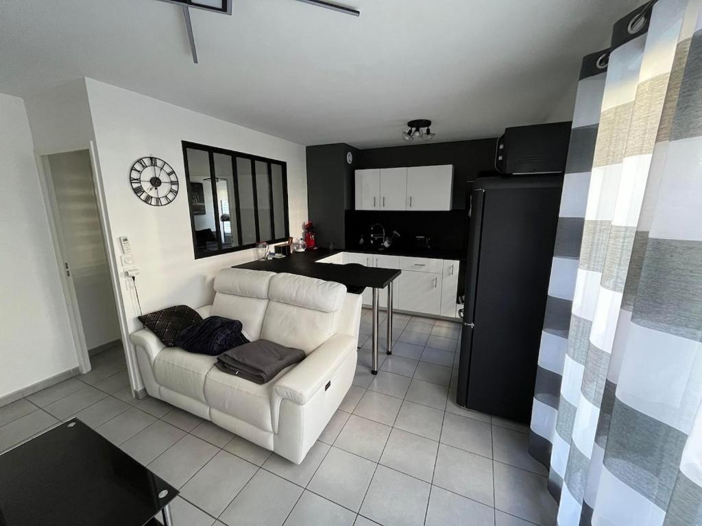 un salon avec un canapé blanc et une cuisine dans l'établissement Since 1996 - Groupama Stadium, LDLC Arena, Eurexpo, Lyon, Appartement Calme, à Décines-Charpieu