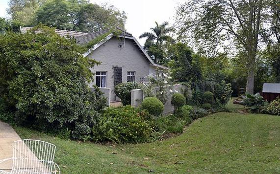 una casa blanca con una valla y un patio en A Garden Suite B&B, en Pietermaritzburg