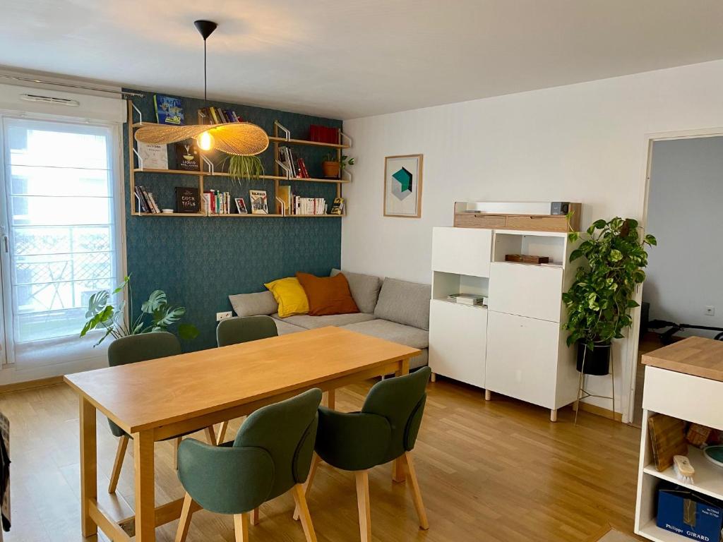 un salon avec une table et un canapé dans l'établissement Appartement spacieux et lumineux de 67 m2, 2 balcons, à Saint-Ouen