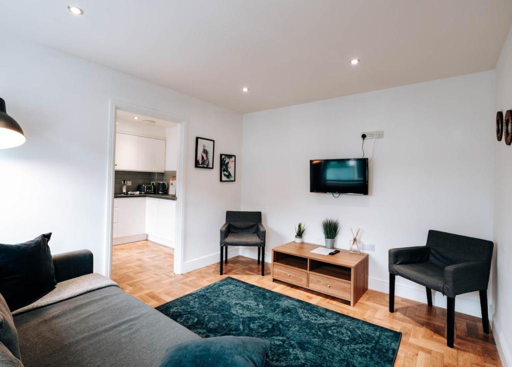 a living room with a couch and a tv at Prosper House Apartment 3 in Norwich